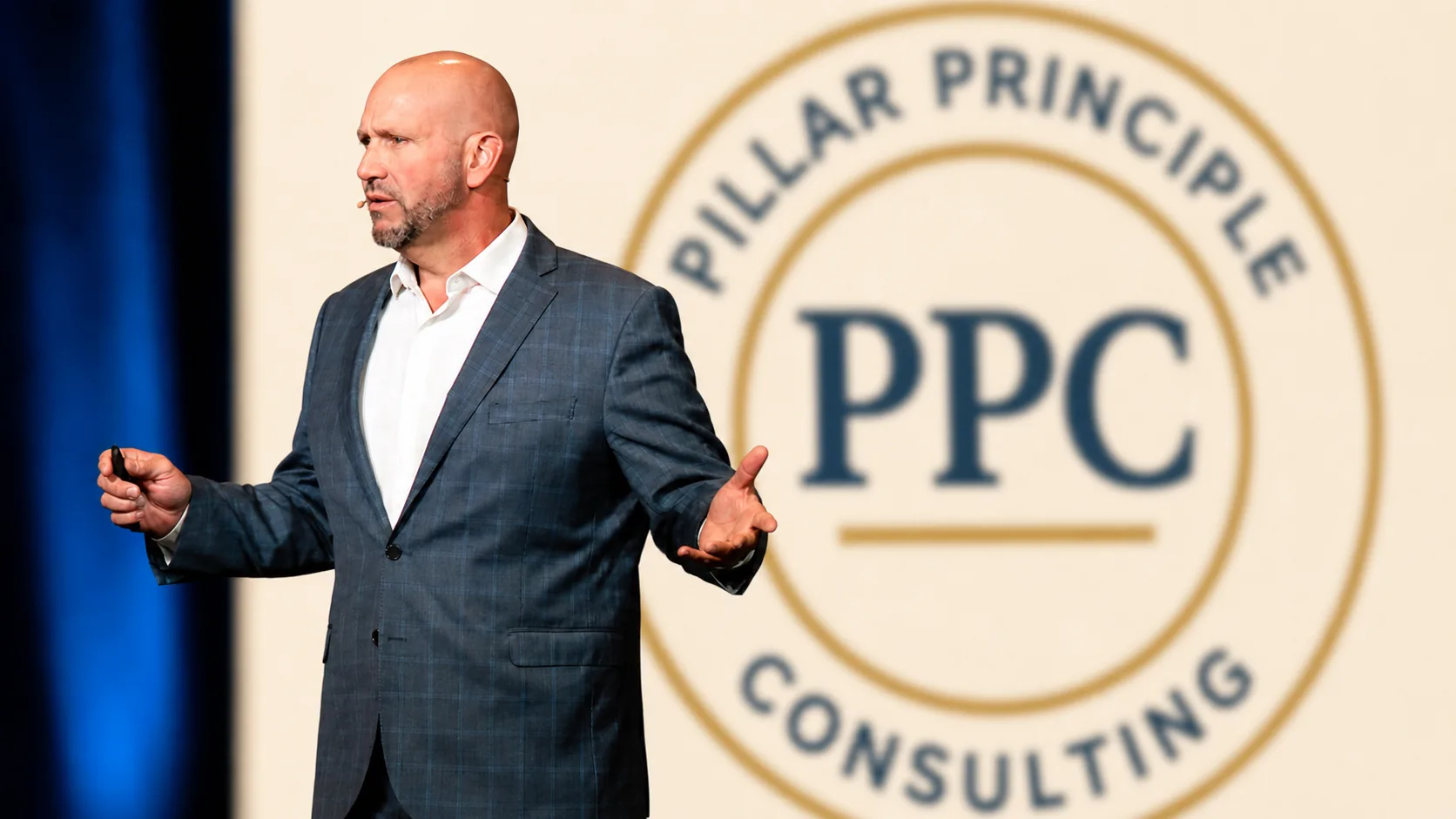 Paul Beiler delivering a keynote address with the Pillar Principles Consulting seal behind him